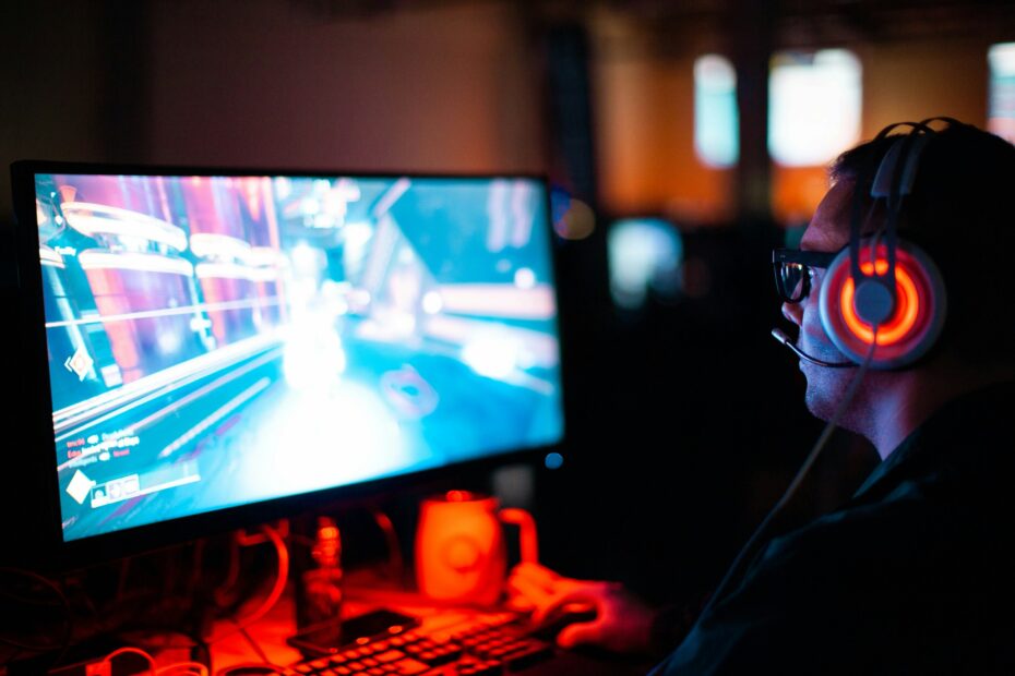 Persona che usa il computer mentre gioca a un gioco FPS - Immagine di un uomo gratuito su Unsplash